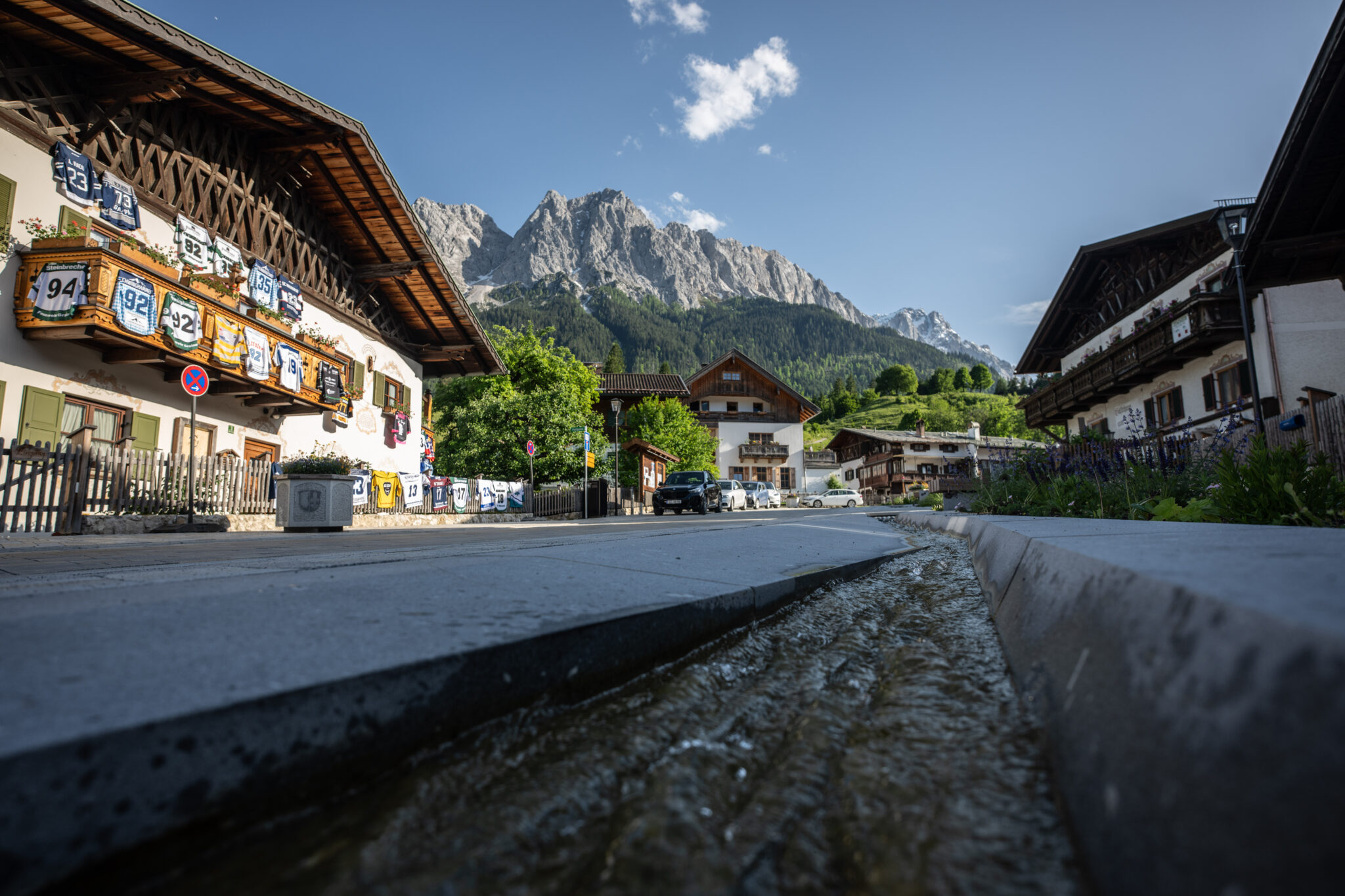 Oberer Dorfplatz in Grainau im Hintergrund Waxensteine und Zugspitze mitBachlauf