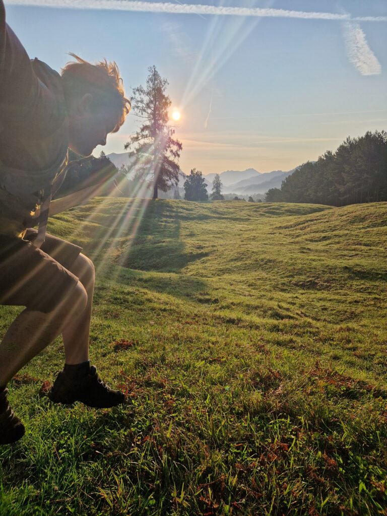 spingendes Kind am Höhenrain bei Sonnenaufgang