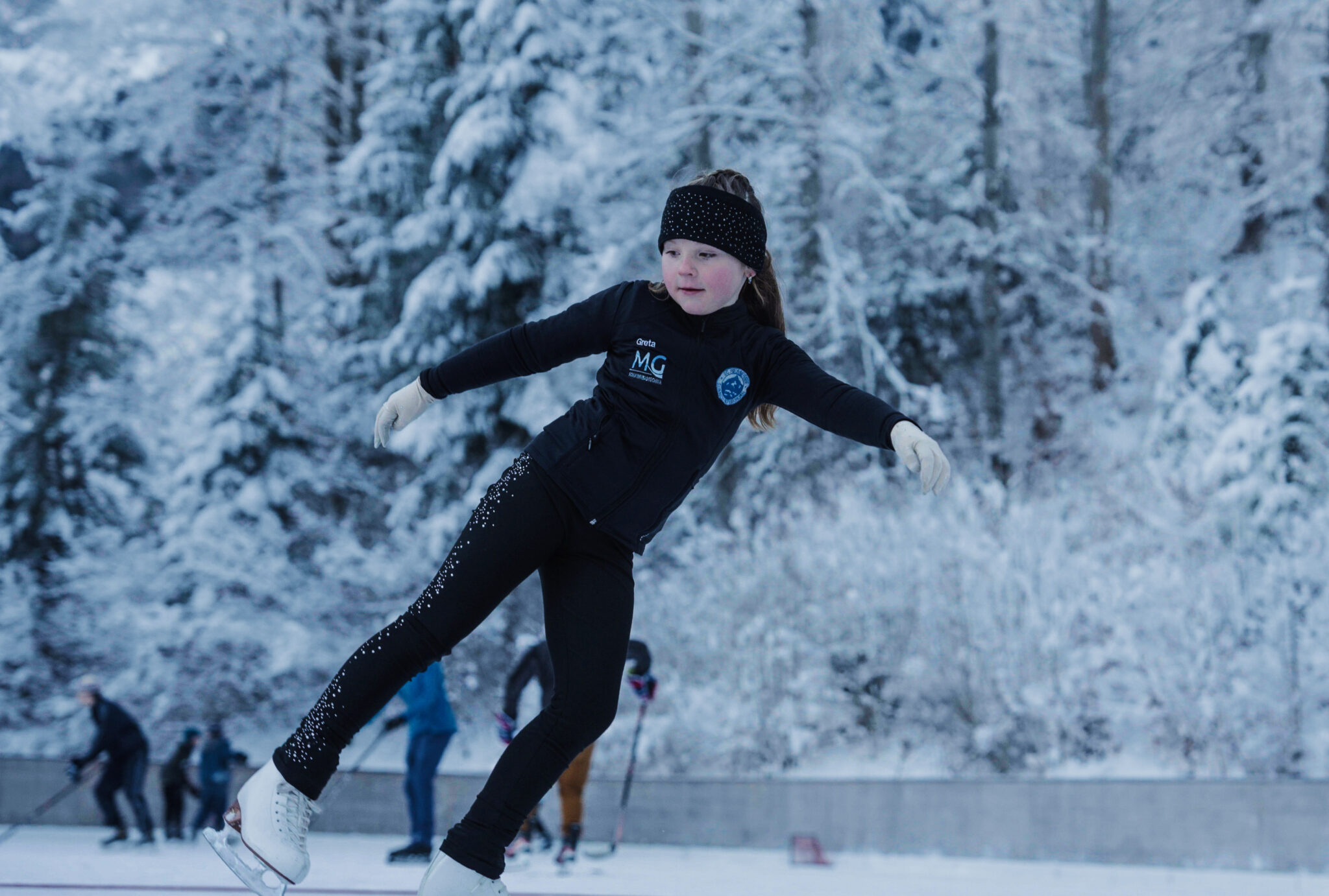 Mädchen mit Schlittschuhen auf Grainauer Eisplatz