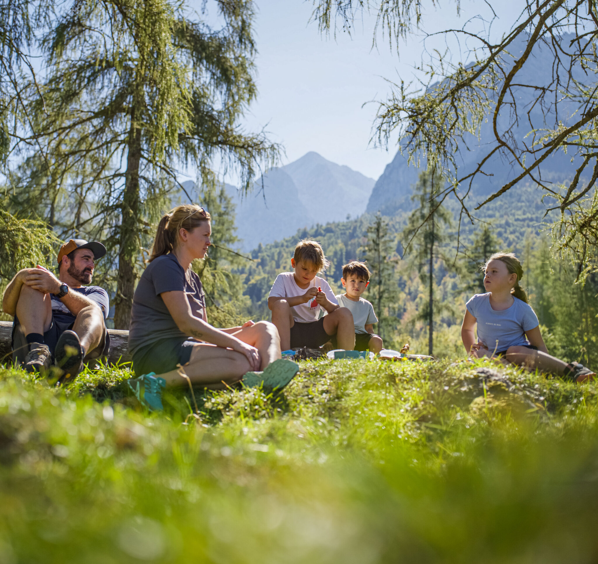 Familie macht Brotzeit an Brotzeitplatz am sagenhaften Bergwald in Grainau