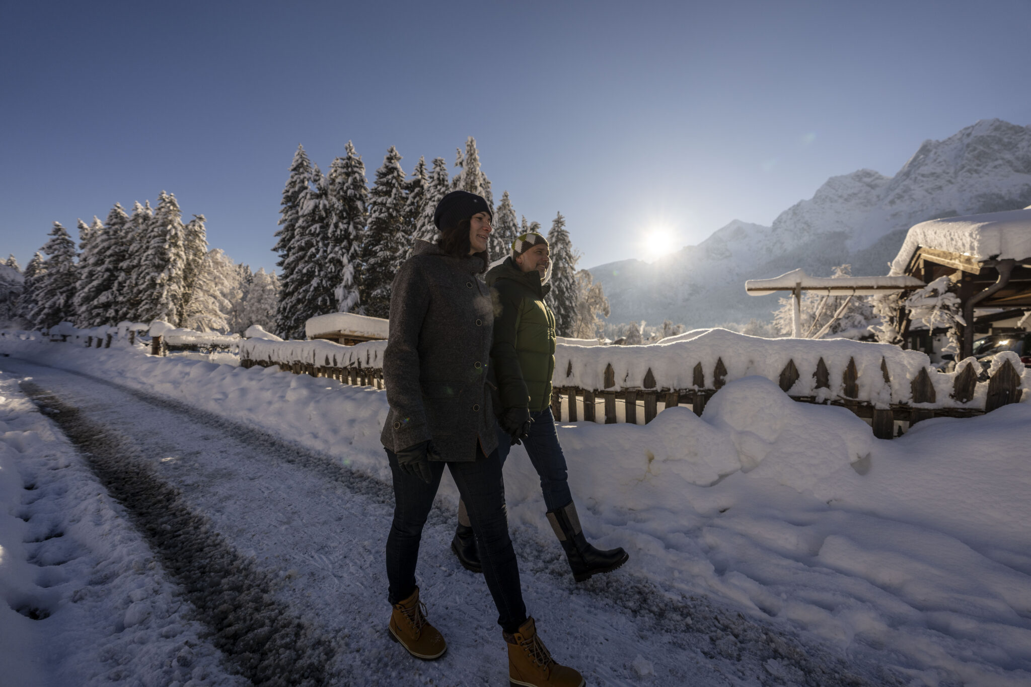 Wanderpaar auf tief verschneiten Wanderweg Hintergrund Berge und Sonne