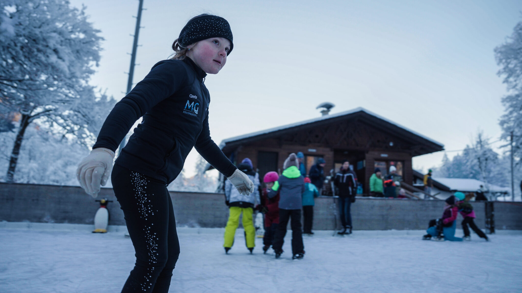 Mächen auf Eisplatz Grainau mit Hütte im Hintergrund