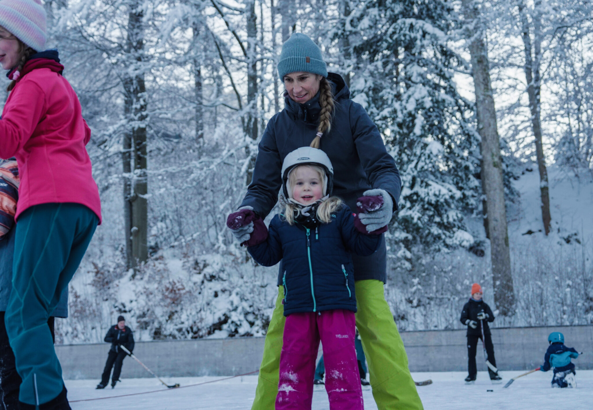 Mutter mit Tocheter beim Schlittschuhfahren in Grainau auf Natureisplatz