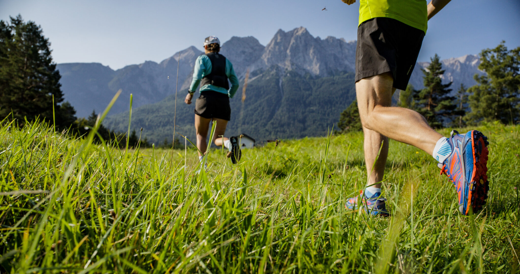 Trailrunning in Grainau – Läufer auf Wiese im Hintergrund Waxensteine und Zugspitze